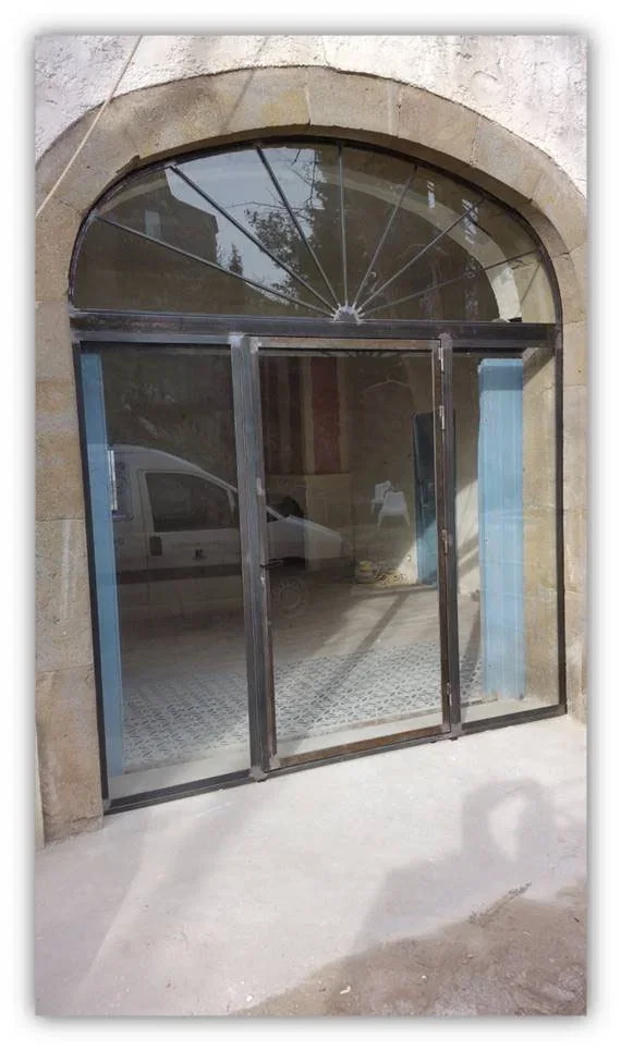 Porte vitrée avec parties fixes sur les côtés et imposte cintrée en partie haute