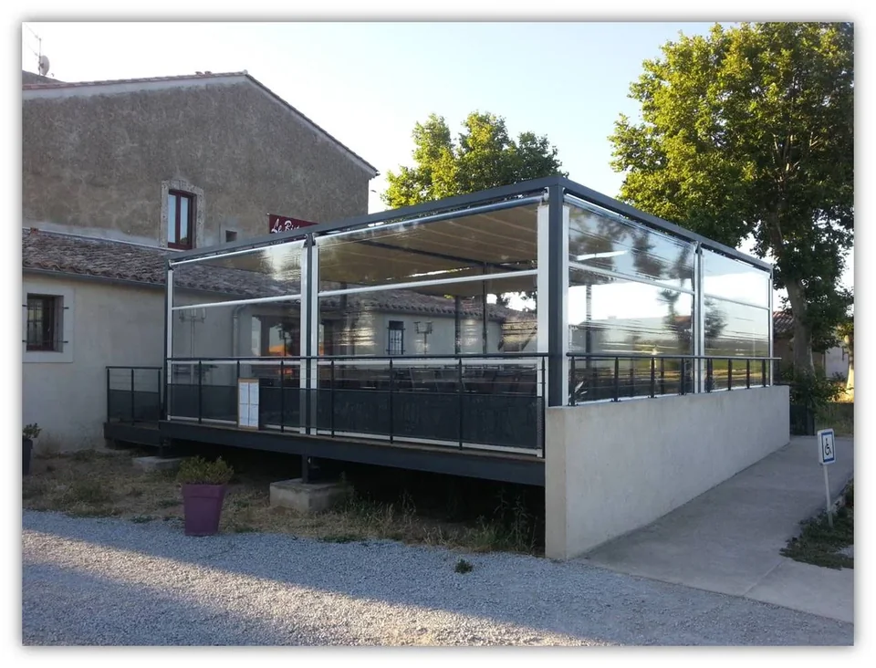 Pergola de restaurant avec toiles coulissantes tendues et stores pare-vent transparents