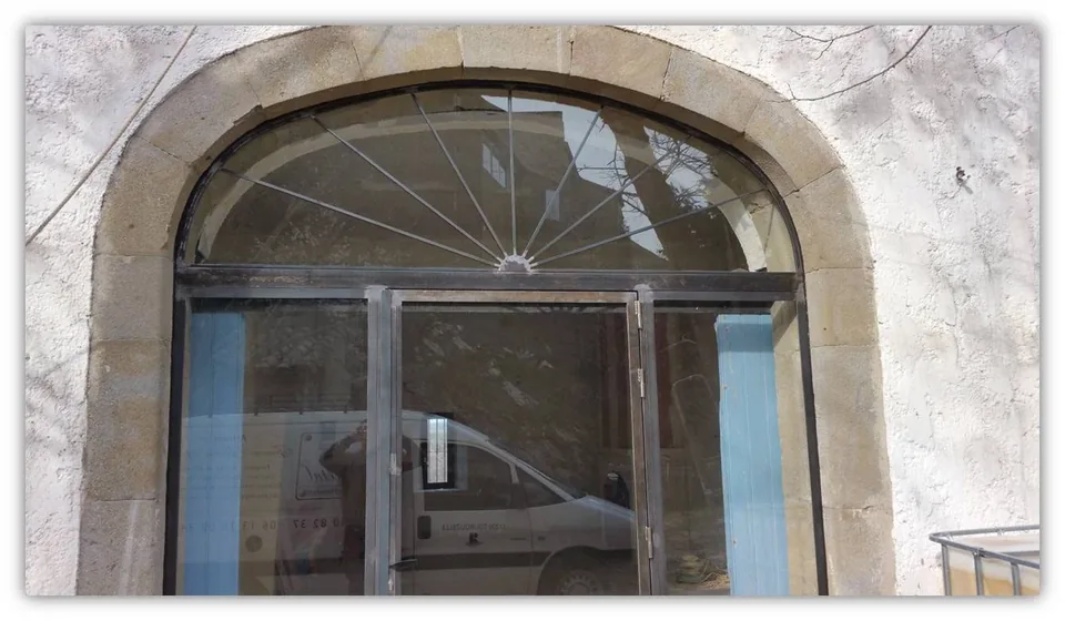 Porte vitrée avec parties fixes sur les côtés et imposte cintrée en partie haute